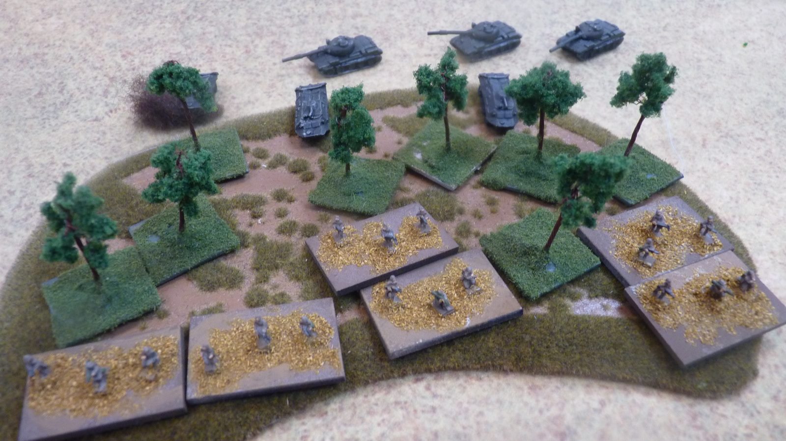 Angolan infantry deploy into some brush as their tanks manouevre behind them